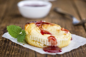 Cheesecake with Sauce on an old wooden table as detailed close-up shot (selective focus)