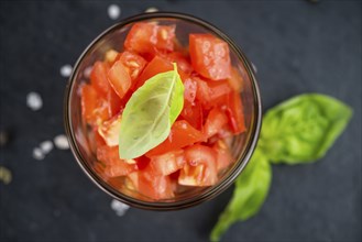 Portion of Cutted Tomatoes as detailed close up shot on a slate slab (selective focus)