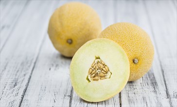 Honeydew Melon on an old wooden table as detailed close-up shot (selective focus)