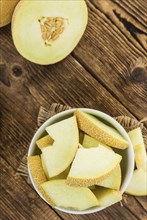 Honeydew Melon on an old wooden table as detailed close-up shot (selective focus)