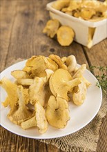 Fresh harvested Chanterelles (on a wooden table) as detailed close-up shot