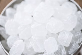 Portion of Rock Sugar (selective focus) on a wooden table