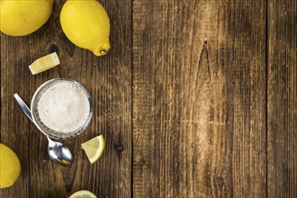 Vintage wooden table with Lemon powder (selective focus, close-up shot)