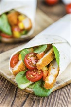 Chicken Wraps on a wooden table as detailed close-up shot (selective focus)