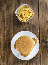 Fish Burger (selective focus, close-up shot) on wooden background