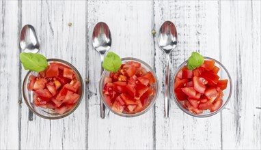 Homemade Diced Tomatoes on an wooden table (selective focus) as detailed close-up shot