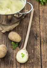 Potato Mash on rustic wooden background (close-up shot)