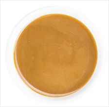 Portion of Caramel Sauce as detailed close up shot on a slate slab (selective focus)