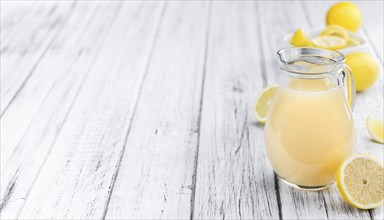 Fresh made Juice (lemon) on an old and rustic wooden table (selective focus, close-up shot)