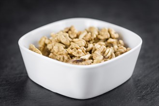 Portion of Cracked Walnuts on a rustic slate slab (selective focus, close-up shot)