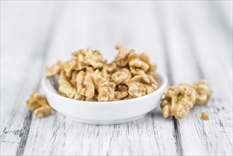 Walnuts (kernels) on an old wooden table as detailed close-up shot (selective focus)