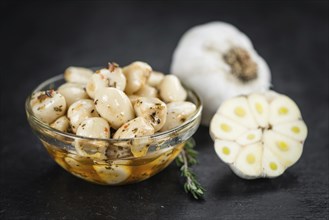 Portion of Garlic (preserved) on a rustic slate slab (selective focus, close-up shot)