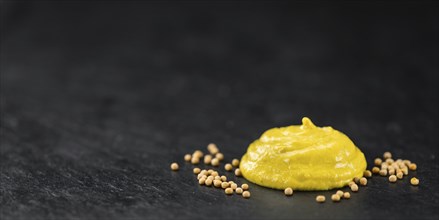 Fresh made Mustard on a vintage background (close-up shot)