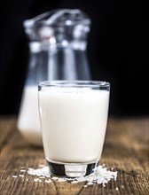 Wooden table with Rice Milk (detailed close-up shot, selective focus)