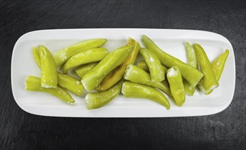 Some fresh Stuffed green Chilis on a vintage slate slab (selective focus, close-up shot)