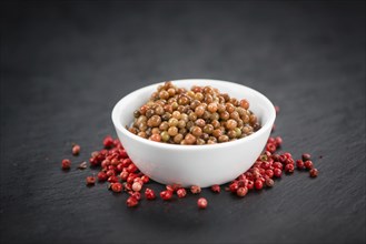 Some preserved Pink Peppercorns on a vintage slate slab, selective focus