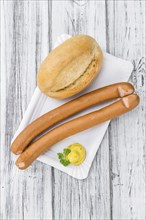 Sausages (Frankfurter) on rustic wooden background (close-up shot)