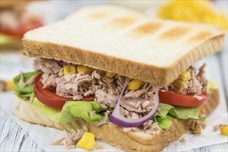 Wooden table with a fresh made Tuna Sandwich (selective focus, close-up shot)