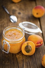 Apricot Jam on an old wooden table as detailed close-up shot (selective focus)