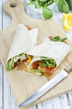 Chicken Wraps on a wooden table as detailed close-up shot (selective focus)