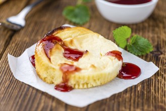 Fresh made Mini Cheesecake (with Sauce) on a vintage background (close-up shot)