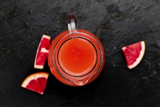 Portion of freshly squeezed Grapefruit Juice on a vintage background (selective focus, close-up