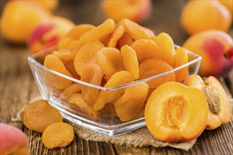 Dried Food (Apricots) on rustic wooden background (close-up shot)