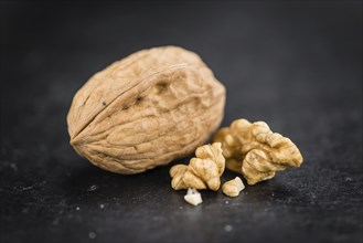 Portion of Whole Walnuts on a rustic slate slab (selective focus, close-up shot)