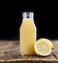 Homemade Lemon Juice on an wooden table (selective focus) as detailed close-up shot