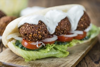 Falafel Sandwich (close-up shot) on an old wooden table