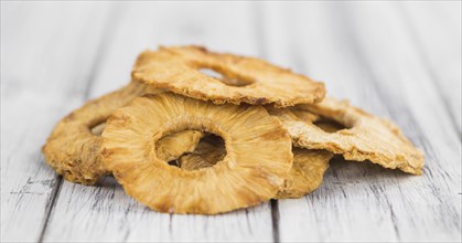 Pineapple rings (dried) on rustic wooden background as close-up shot