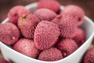 Lychees on a vintage background as detailed close-up shot (selective focus)