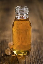 Syrup (Caramel taste) on an old wooden table as detailed close-up shot (selective focus)