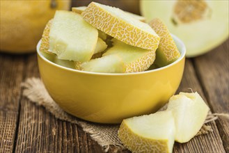 Honeydew Melon on an old wooden table as detailed close-up shot (selective focus)