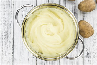 Portion of homemade Mashed Potatoes on wooden background (selective focus, close-up shot)