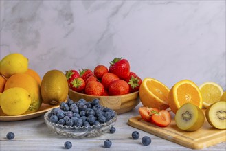 Harmonious still life of various fruits, strawberries, lemons, oranges, kiwis and blueberries,