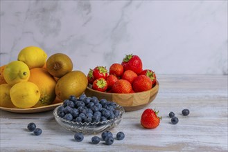 Harmonious still life of various fruits, strawberries, lemons, oranges, kiwis and blueberries on