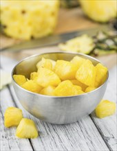 Sliced Pineapple on rustic wooden background as close-up shot