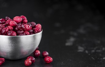 Portion of healthy Dried Cranberries on a slate slab (selective focus)