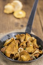 Fresh made Fried Chanterelles on a vintage background as detailed close-up shot