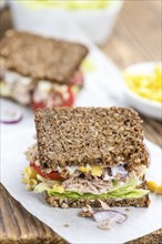 Old wooden table with Tuna sandwich (on wholemeal bread, selective focus)