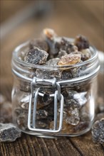 Wooden table with brown Rock Candy (close-up shot, selective focus)