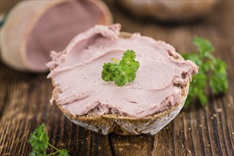 Roll with Liverwurst (German cuisine) on an old wooden table as detailed close-up shot (selective