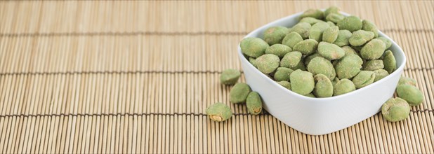 Wasabi Peanuts on a vintage background as detailed close-up shot (selective focus)