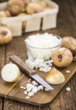 White Onions (dices) as high detailed close-up shot on a vintage wooden table, selective focus