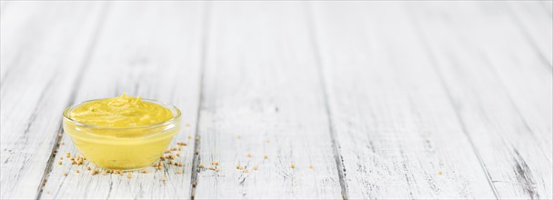 Mustard as high detailed close-up shot on a vintage wooden table (selective focus)