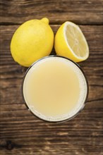 Homemade Lemon Juice on an wooden table (selective focus) as detailed close-up shot