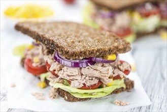 Old wooden table with Tuna sandwich (on wholemeal bread, selective focus)