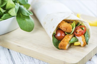 Chicken Wraps on a wooden table as detailed close-up shot (selective focus)