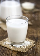 Wooden table with Rice Milk (detailed close-up shot, selective focus)